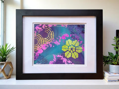 Framed abstract artwork with floral design on a white surface